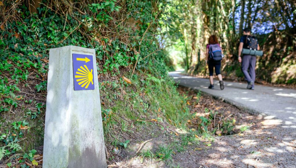 milestone-of-saint-james-way-with-pilgrims-walking-2025-03-15-13-30-56-utc